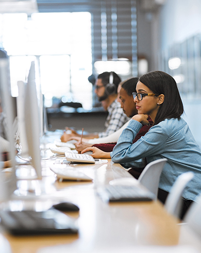 Studentin am Laptop in einer Bibliothek
